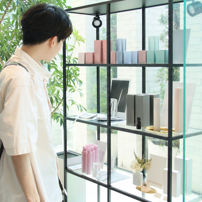 美容室の棚で商品を見つけるお客様